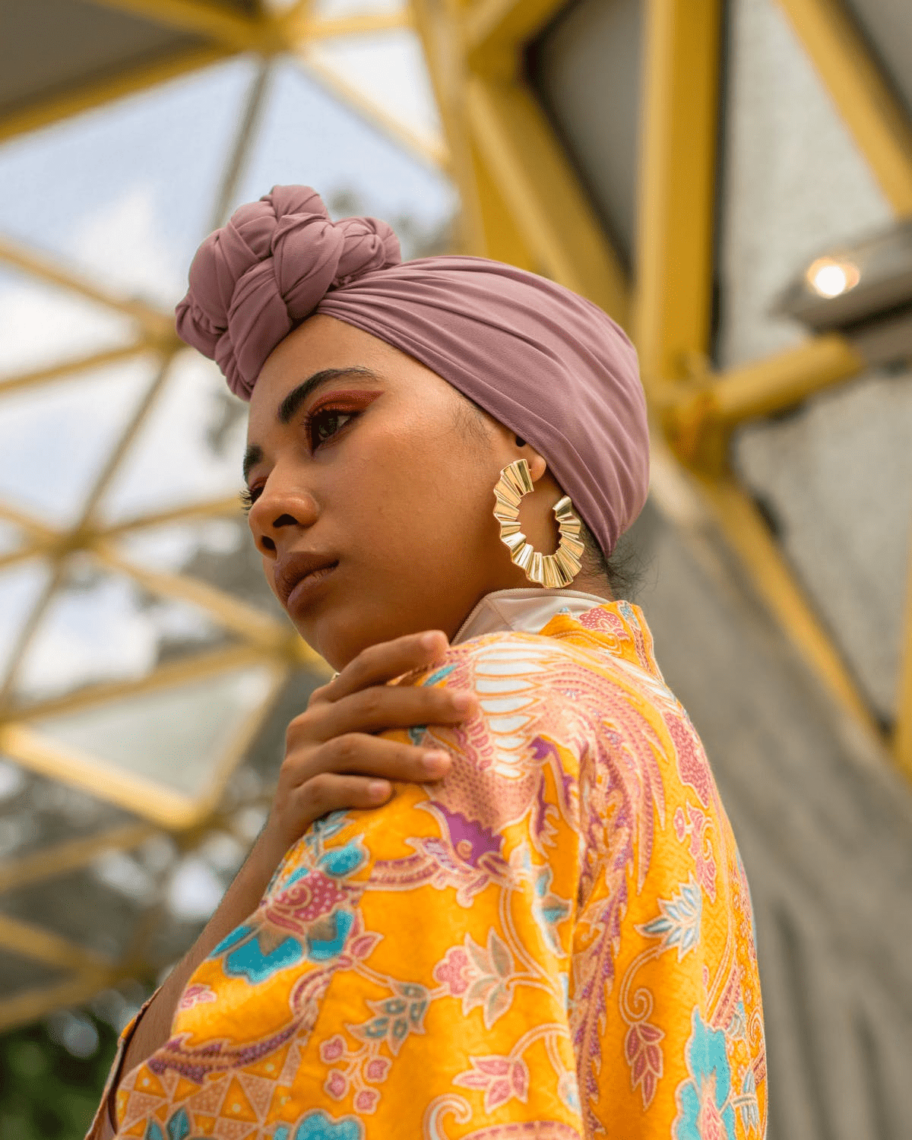 woman with pink scarf and orange robe