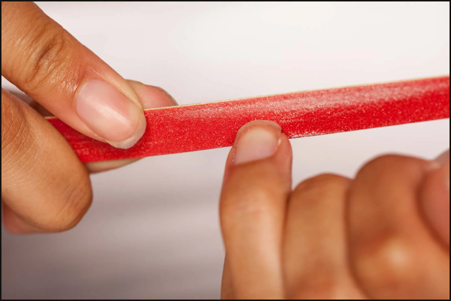 Person filing their nails after removing a polygel manicure.